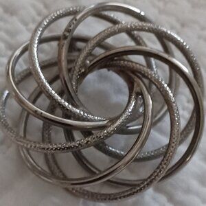 Silver colored, coil brooch